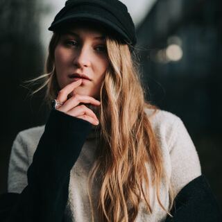 Portrait einer Frau mit schwarzer Kappe im Gegenlicht