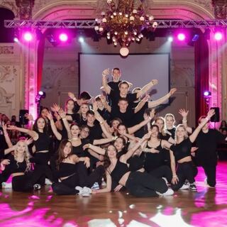 Tanzgruppe bei einer Eventshow auf beleuchteter Bühne