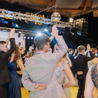 Tanzendes Publikum bei einer Ballnacht mit Bühnenlicht